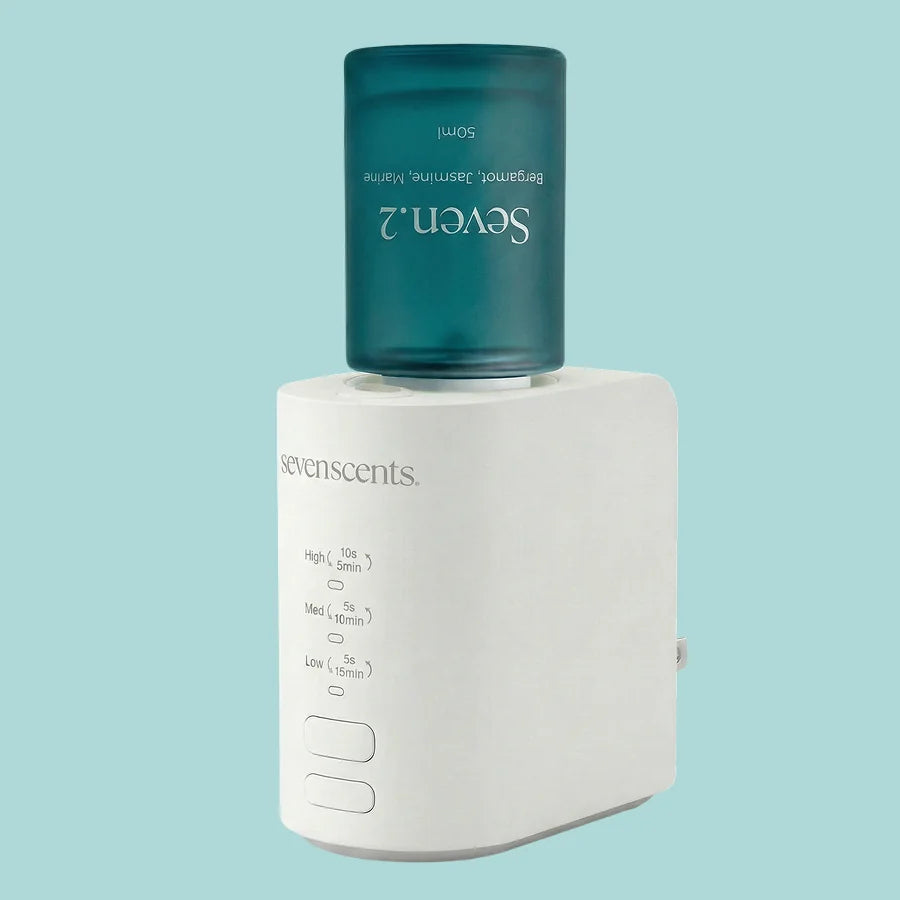 The Spirit diffuser with a Seven.2 bottle on top, on a pale aqua background